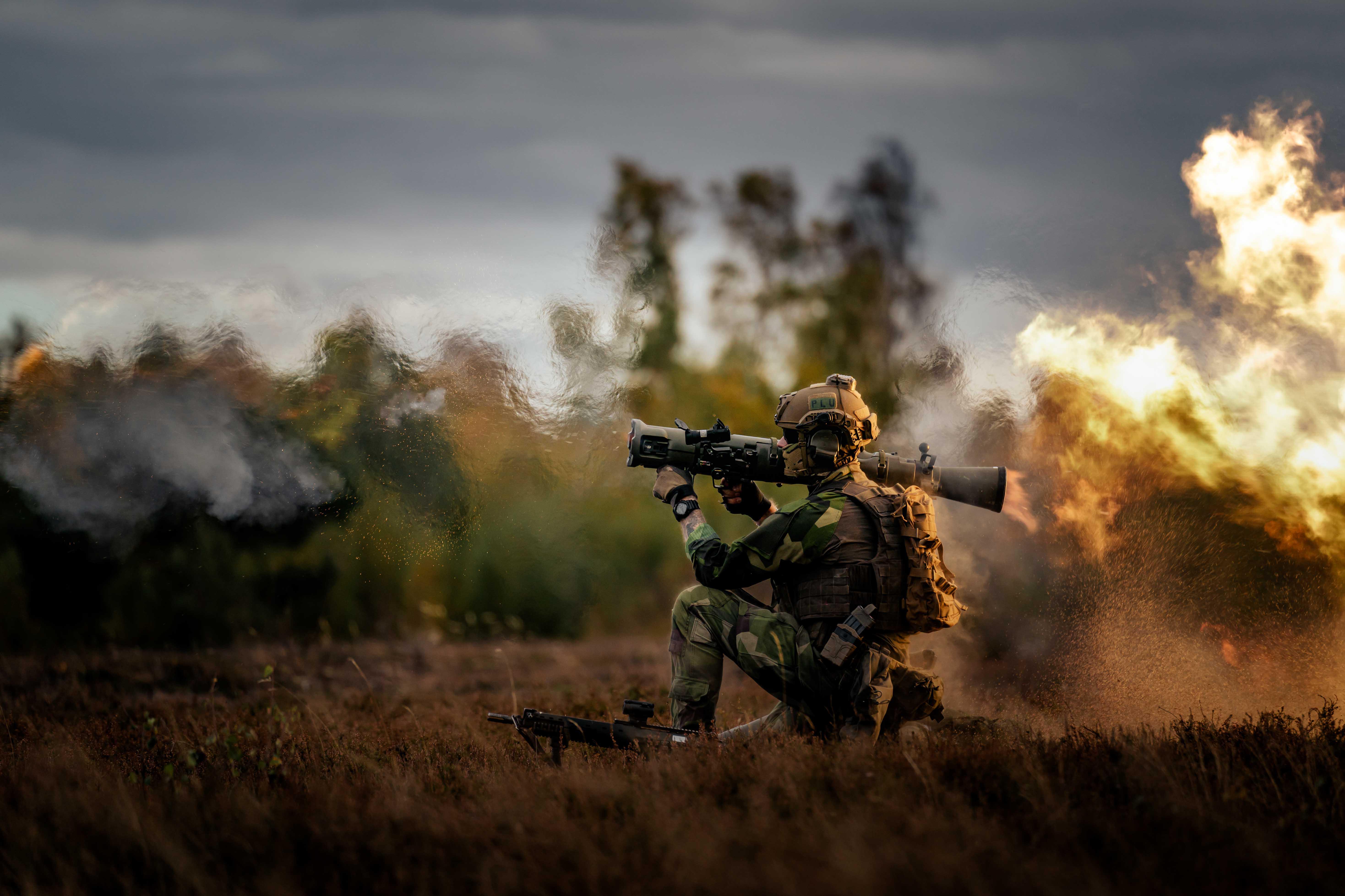 Image shows RAF Regiment holding heavy weapon while kneeling.